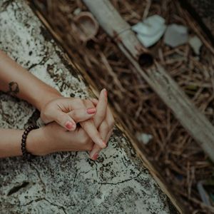 Detail of a person's hands in a meditative pose.